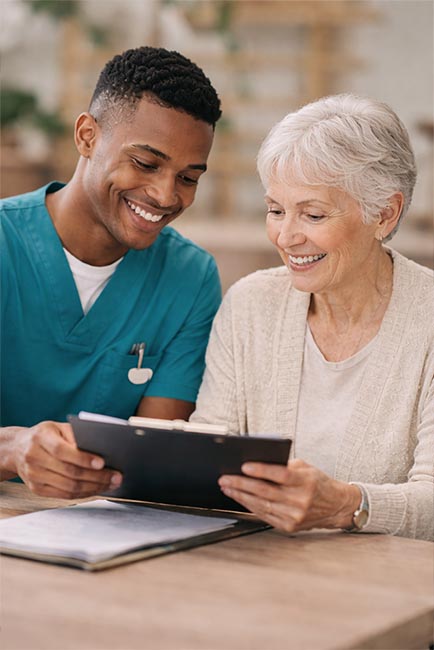 Caregiver and senior reviewing a care plan on a tablet